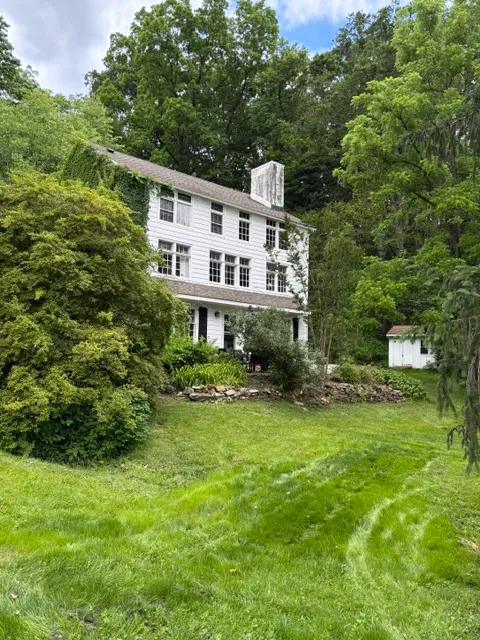 Colonial exterior surrounded by mature trees